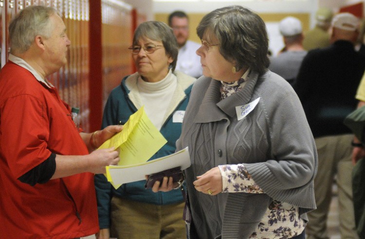 People walk to workshops during the opiate symposium at Cony High School in Augusta on Wednesday night.