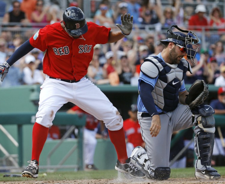 Xander Bogaerts of the Boston Red Sox slips past Tampa Bay catcher Curt Casali to score on a single by David Ortiz in the fourth inning of Tampa Bay’s 3-2 victory Monday.