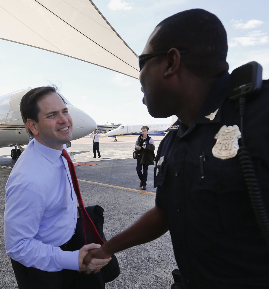 Sen. Marco Rubio shakes hands with a police officer in Tampa, Fla., Monday. That state’s primary is next week.