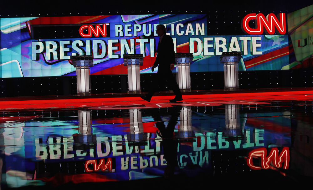 A CNN staffer walks across the stage where the Republican presidential debate sponsored by CNN, Salem Media Group and the Washington Times will take place, at the University of Miami, on Thursday in Coral Gables, Fla.