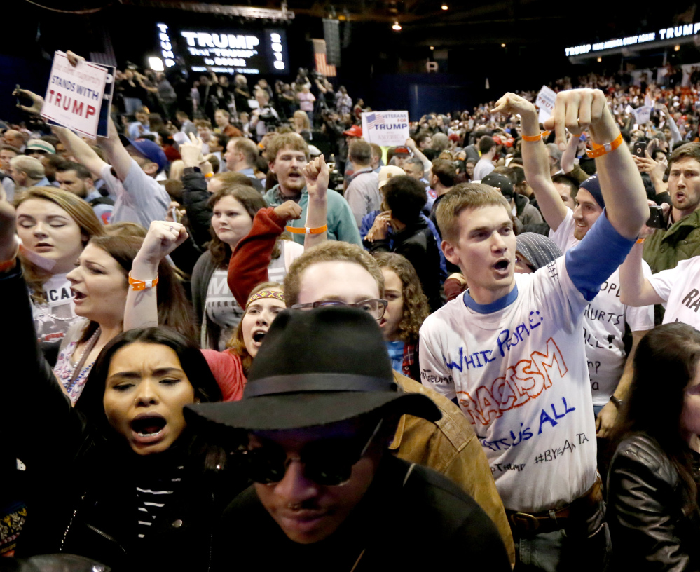 Protesters of Republican presidential candidate Donald Trump, right, chant after a rally on the campus of the University of Illinois-Chicago, was canceled due to security concerns Friday, March 11, 2016, in Chicago.