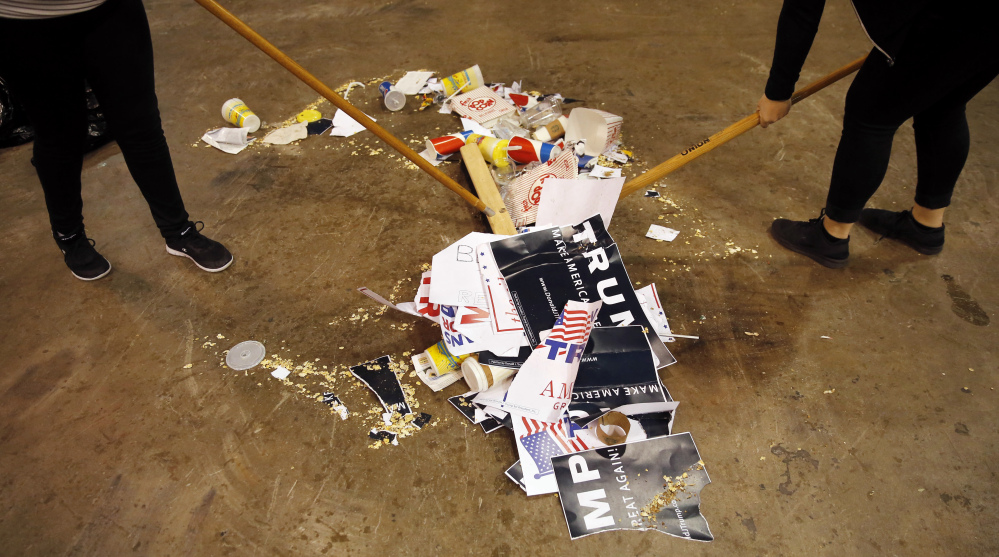 The Associated Press
Trash is scooped up, including torn campaign signs for Republican presidential candidate Donald Trump, after a rally for Trump was canceled due to security concerns, on the campus of the University of Illinois-Chicago, Friday, March 11, 2016, in Chicago.