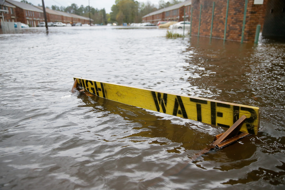 Floodwaters partially submerge a “high water” sign on Rufus Bankston Road west of Hammond, La., on Friday.