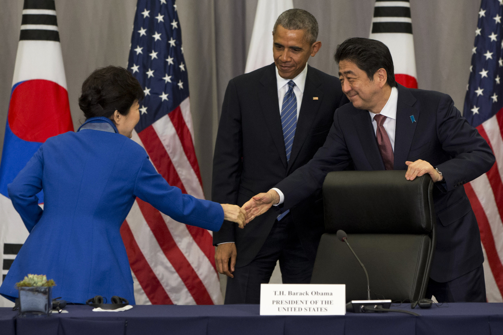 South Korean President Park Geun-hye, left, shakes hands with Japanese Prime Minister Shinzo Abe after they met with President Barack Obama at the Nuclear Security Summit in Washington on Thursday.