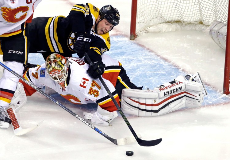 Bruins left winger Matt Beleskey reaches over Calgary goalie Joni Ortio during the first period Tuesday.   The Associated Press