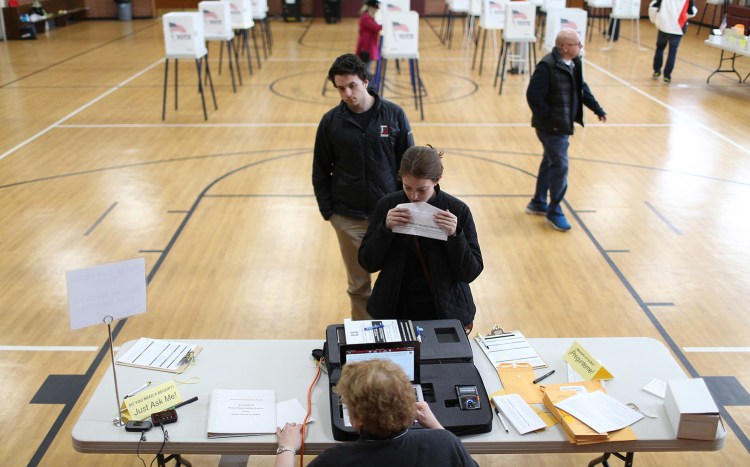 Voters in Highland Park, Ill., pick up ballots during the primary election in March.