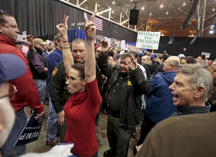 An anti-Trump protester is escorted out of the arena during a campaign rally for Republican U.S. presidential candidate Donald Trump in Cleveland Saturday. The Associated Press