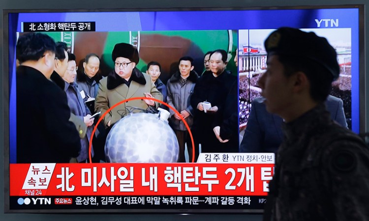 A South Korean army soldier walks by a TV screen showing North Korean leader Kim Jong Un with superimposed letters that read: "North Korea's nuclear warhead" during a news program at Seoul Railway Station in  South Korea.