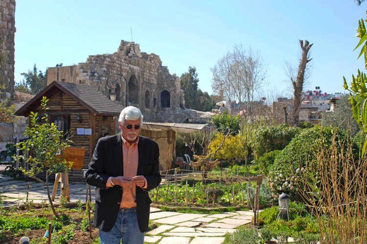 Thomas Webber walks in a garden next to the Citadel of Damascus, Syria. Webber, an American who was born and raised in Orchard Park, New York, has a part-time job in the English department of a local high school, where he shares his love of Charles Dickens with teenagers several times a week. The Associated Press
