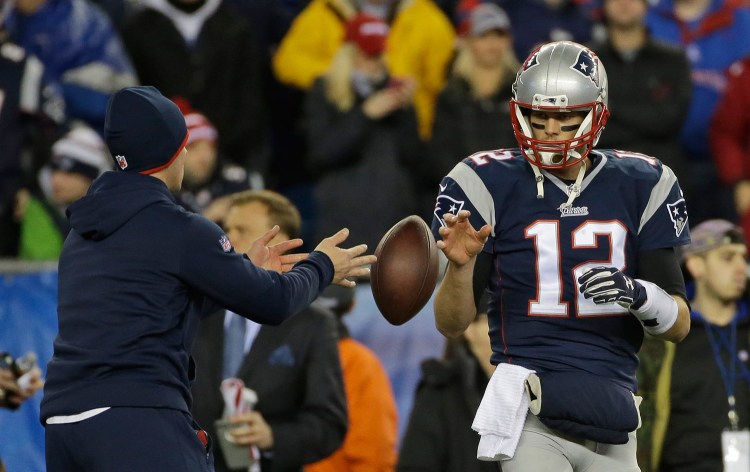 A football is tossed to Tom Brady during warmups before the AFC Championship game in January 2015, the game that started the "Deflategate" case. A federal appeals court ruled Monday that Brady must serve a four-game suspension imposed by the NFL for his role in the underinflation of footballs used in the game.