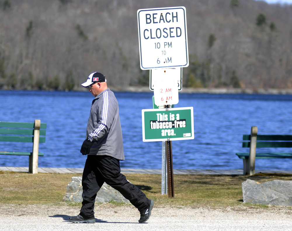 Chris Kempton walks past Winthrop's town beach Tuesday, a day after the Winthrop Town Council approved banning the use of e-cigarettes at the beach.