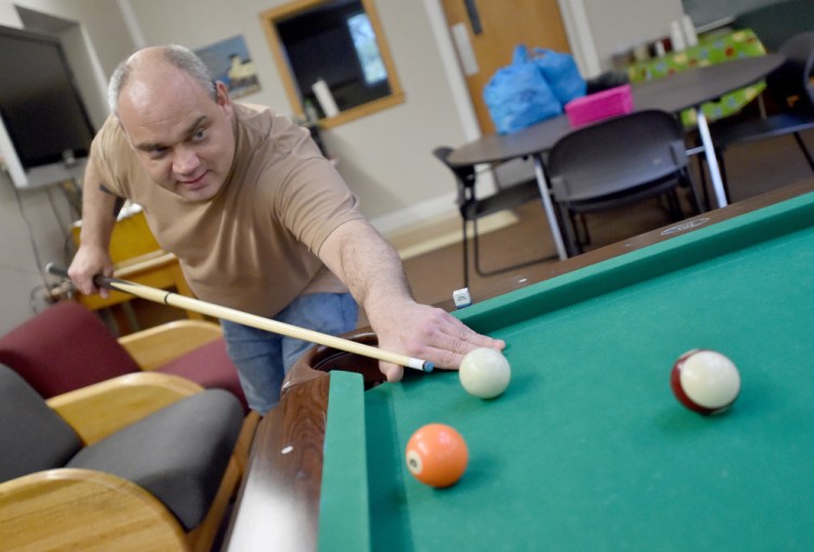 Andrew Zelonis plays a game of pool after helping with the taco dinner clean-up at the Waterville Social Club on Ticonic Street on Friday. The club faces new state-imposed requirements that officials fear could exclude some club members.