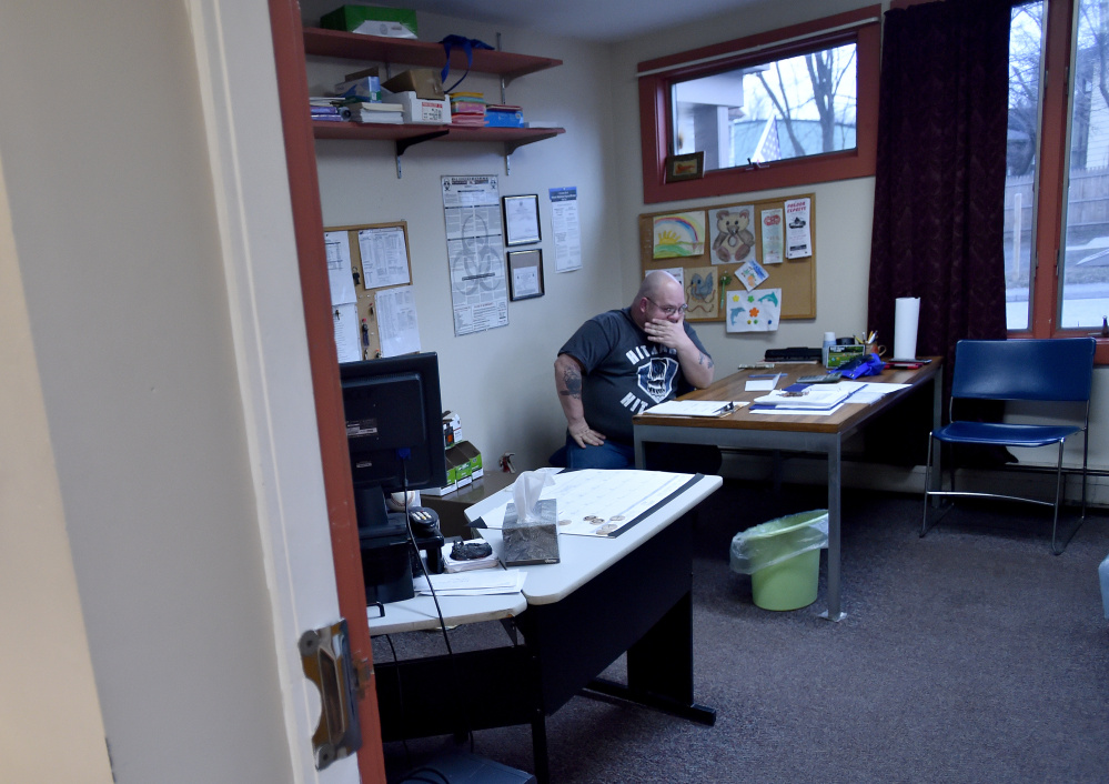 Myron Hutchins, a staff member at the Waterville Social Club on Ticonic Street, does the books at the end of the day on Friday. Hutchins is one of two staff members at the social club, which faces new state-imposed requirements that officials fear could exclude some club members.