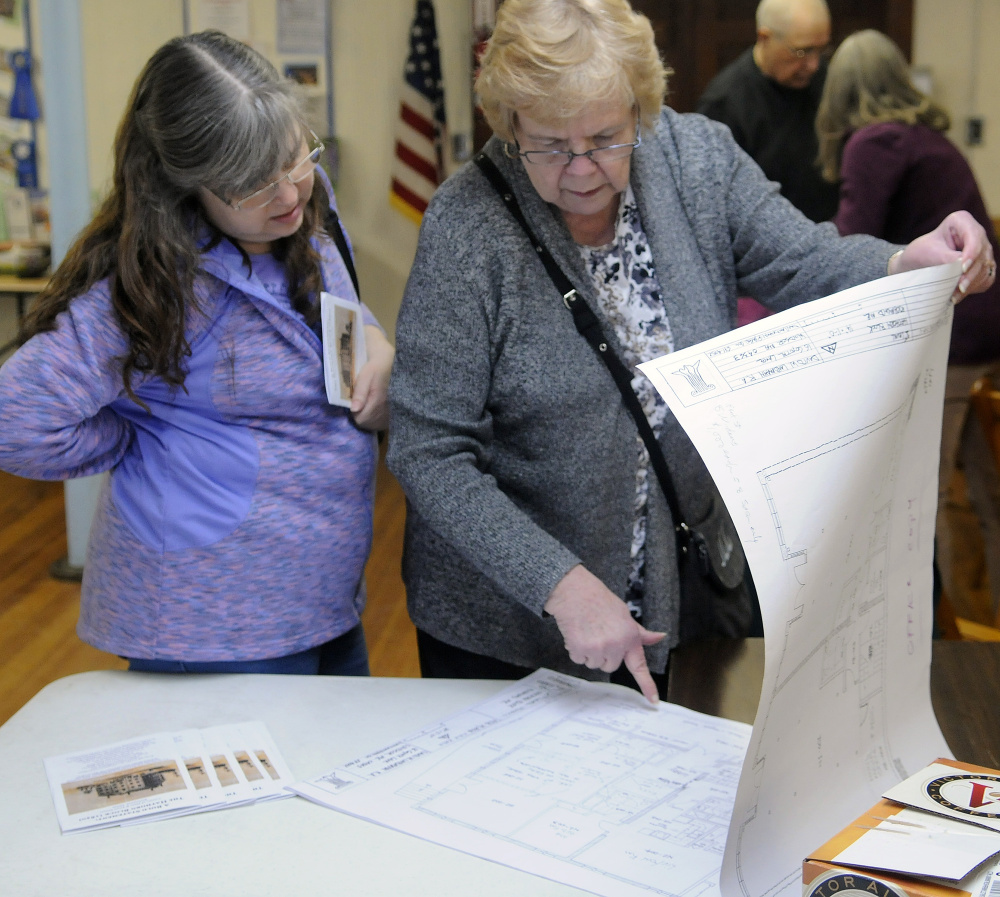 Jackie Lewis, right, and Betsy Lewis-Bowie examine plans for the Hathorn Block in Richmond during a talk on Sunday in Richmond by developer Les Fossel.
