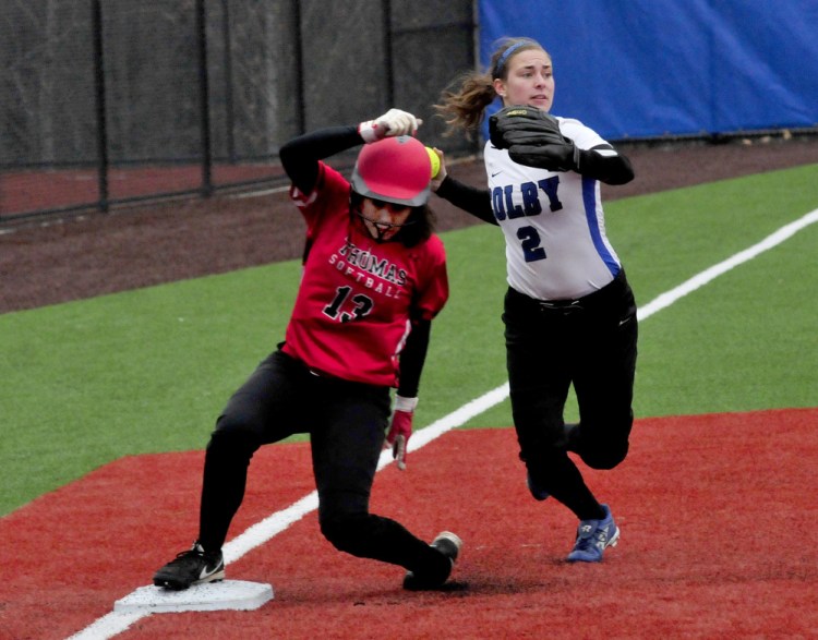 Colby College player Katie McLaughlin looks to throw to first after tagging out Thomas College runner Courtney Veilleux at third base during a game on Monday in Waterville.