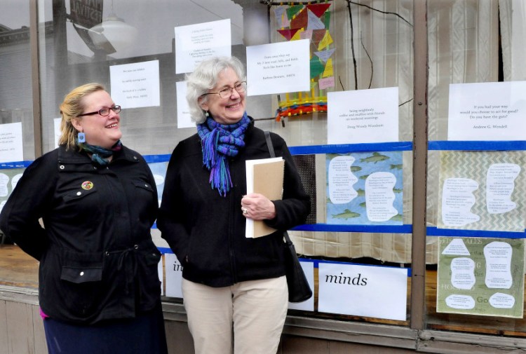 Serena Sanborn, left, and Nina Pleasants speak about the haiku poems and artwork on the front window of the former Variety Drug store in Skowhegan on Monday. The Wesserunsett Arts Council is sponsoring Japanese haiku poems all over Skowhegan as part of poetry month.