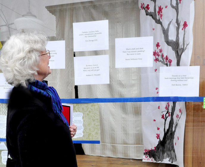 Nina Pleasants admires haiku poetry and artwork in a Skowhegan downtown store front on Monday.