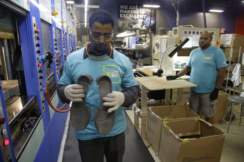 Joao Rodrigues, left, removes a pair of newly formed midsoles for the proposed New Balance 950v2 sneaker in July. The sneaker has passed military testing and would be used by the military. The company and Maine's congressional delegation are pressing the Department of Defense and the Obama administration to keep promises that the military will require personnel to use American-made athletic shoes.
