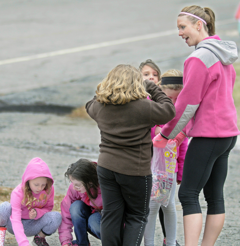 Gilbert Elementary School teacher Paige Knowlton hands out bracelets after school Monday during a run with her students in Augusta. The children and teachers at the school are participating in Girls on the Run, a nationwide program that promotes physical activity and positive youth development.