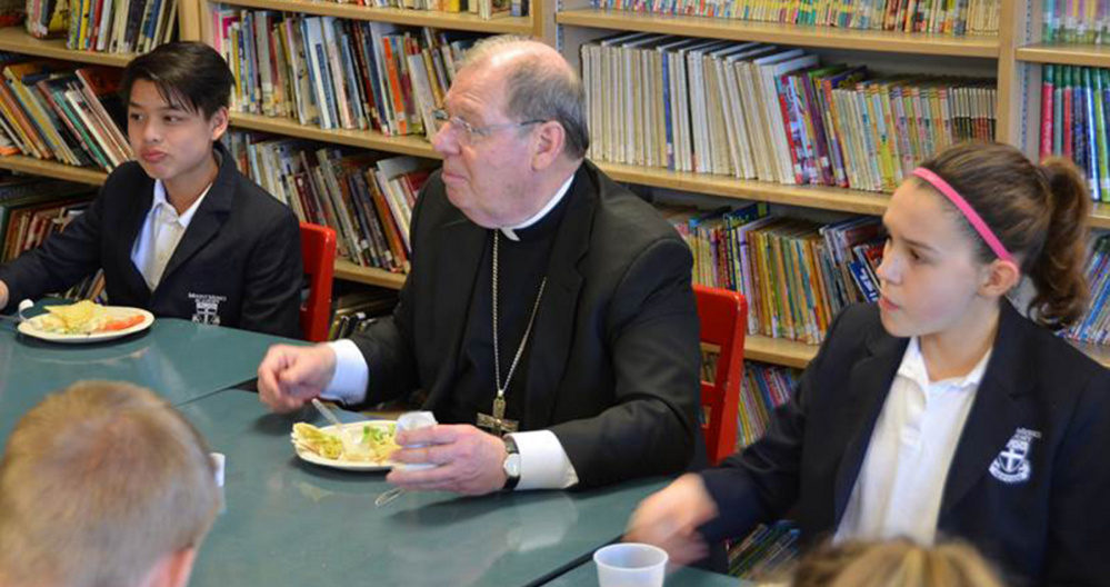 Bishop Robert P. Deeley ate lunch with the eighth graders during his April 13 visit to Mount Merici Academy in Waterville. From left are Yanic Boulet, Bishop Deeley and Lauren Bourque.