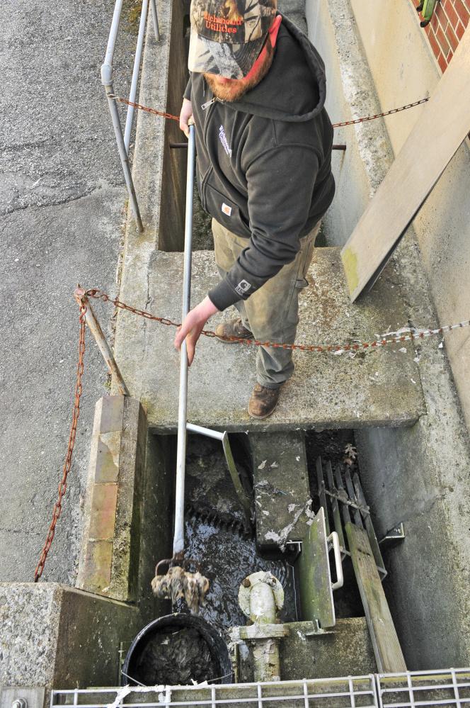 Operator Anthony Soucy rakes the bar rack on Friday at Richmond Utilities District sewage treatment plant.