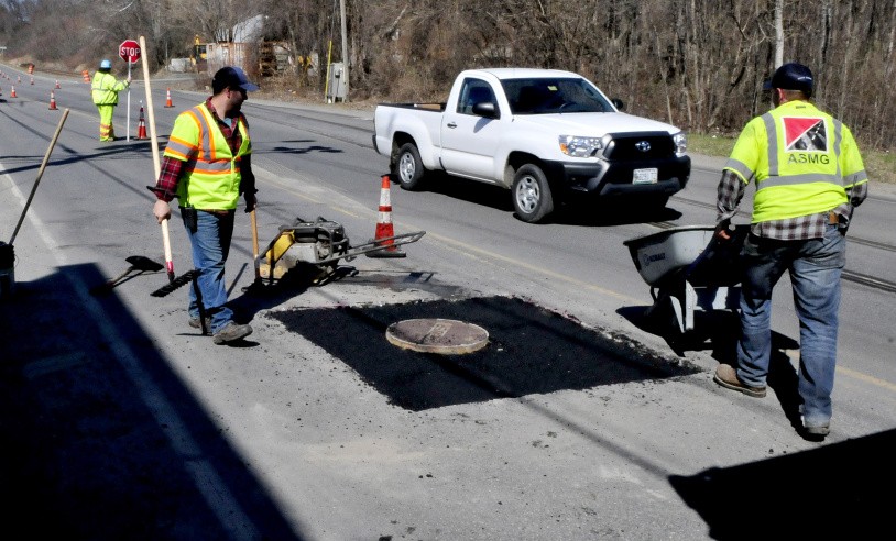 All States Asphalt workers fix paving around sewer covers and catch basins on Bay Street in Winslow on Wednesday. Much-needed paving on the one-mile stretch of the road, which is U.S. Route 201, was delayed because of natural gas pipeline work and winter cold.