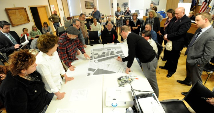 Neil Kittredge, right, draws on a map of Waterville last week to delineate areas of construction during a meeting in the Waterville City Council chamber. Times have been set for the final two of a series of five meetings for downtown businesses and residents to discuss traffic, parking and revitalization plans.