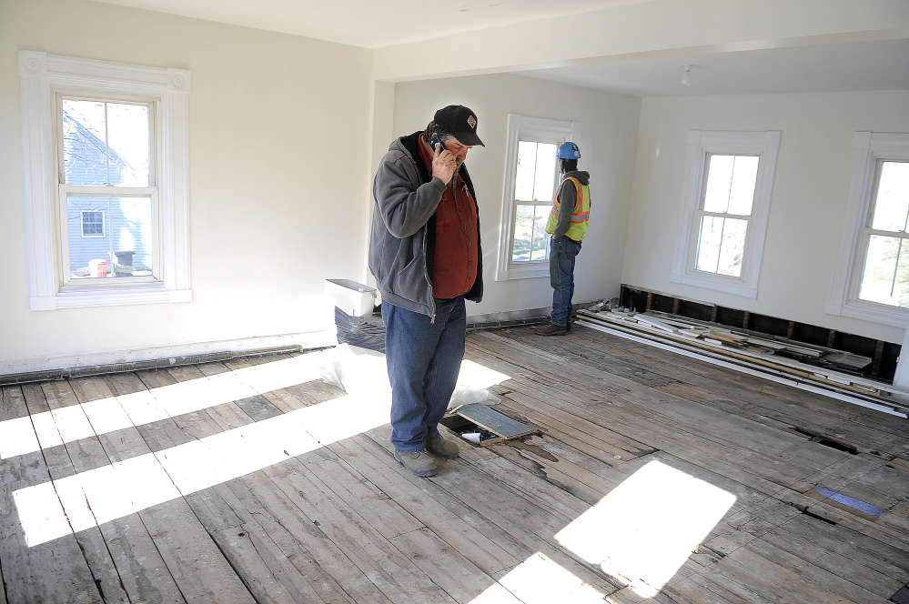 Jon Canty, left, and Adam Mealey inspect the second floor of the house at 226 Water St. in Hallowell on Monday.