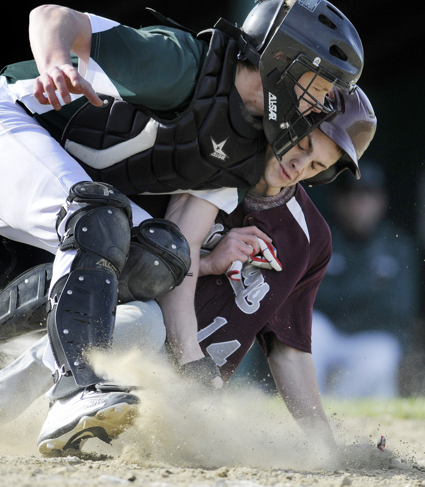Monmouth Academy's Gage Cote slides safely into home under Winthrop catcher Matt Ingram during a Mountain Valley Conference game Monday afternoon in Winthrop.