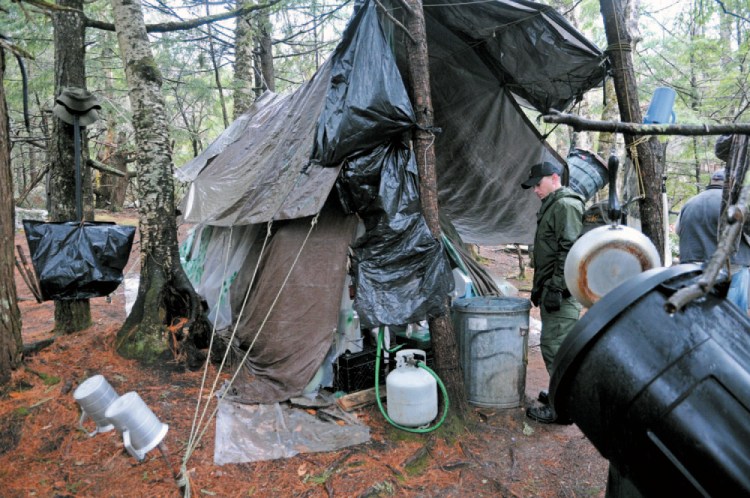 District Game Warden Aaron Cross inspects Christopher Knight's camp in a remote, wooded section of Rome in this file photo. 