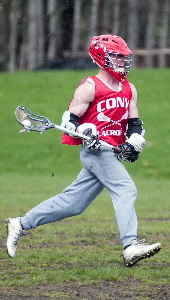 Bret Sproul runs with the ball during lacrosse practice Tuesday at Cony High School in Augusta.