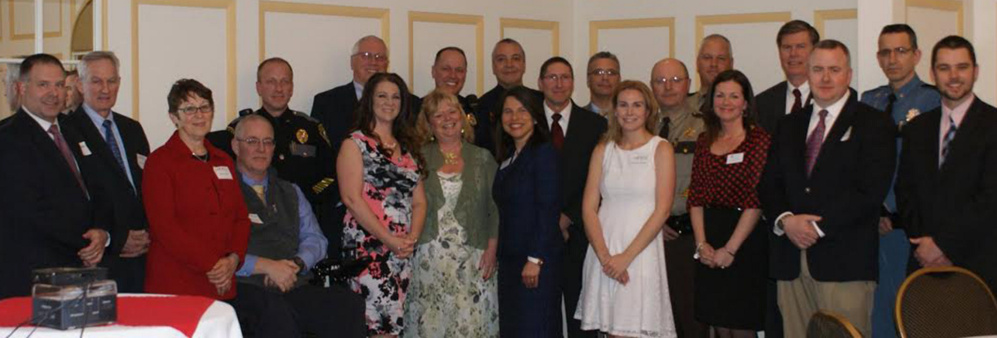 In front, from left, are Jenna McCarthy Mayhew, Donna Strickler, District Attorney Maeghan Maloney, Samantha Marquis, Michelle Galego, Deputy Chief Charles Rumsey and James Martin. In back, from left, are Dale Hamilton, Tom McAdam, Melody Fitch, Chief Robert Gregoire, Chief Craig Johnson, Chief Joseph Massey, Chief Ryan Frost, Chief James Toman, Chief Michael Tracy, Chief Shawn O'Leary, Sheriff Dale Lancaster, Sheriff Ryan Reardon, Chuck Hayes and Lt. Col. John Cote.