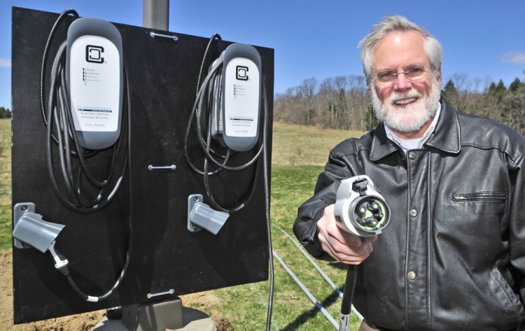 Scott Cowger holds up an electric car charging plug Thursday at the Maple Hill Farm Inn and Conference Center in Hallowell.