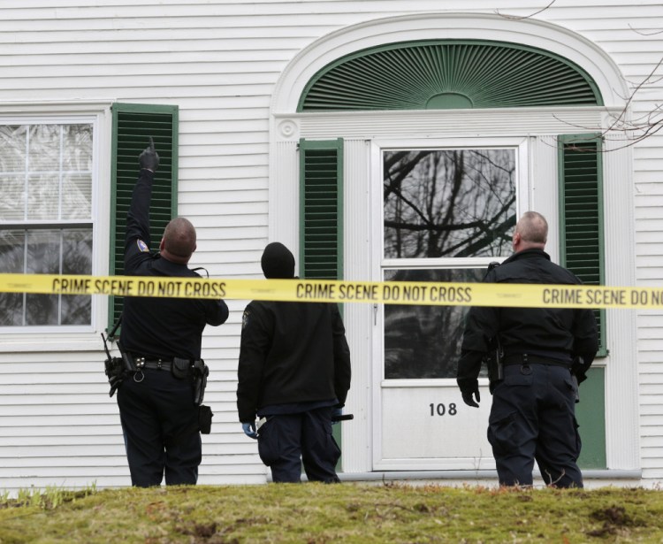 A Westbrook police officer points toward the second floor of a house at 108 Longfellow St. while Maine State Police investigators search the property where a Westbrook police officer shot a man with a handgun who was threatening suicide Saturday morning.