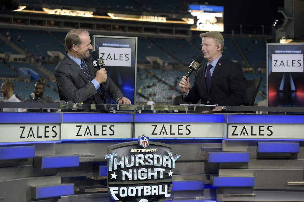Thursday Night Football sportscasters Bill Cowher, left, and Phil Simms broadcast from the set on the field before an NFL football game between the Jacksonville Jaguars and the Tennessee Titans in Jacksonville, Fla. The NFL has picked Twitter to stream its Thursday night games.