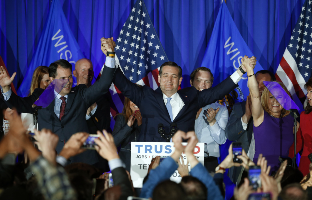Republican presidential candidate Sen. Ted Cruz, R-Texas, raises hands with Wisconsin Gov. Scott Walker, left, and his wife Heidi, right, during a primary night campaign event Tuesday.