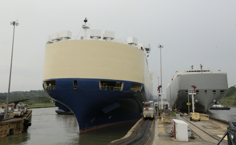 In this July 18, 2014, photo, two cargo ships sails though the Miraflores locks of the Panama Canal in Panama City. The Aug. 15 centennial of the opening of the Panama Canal is being marred by increasing doubts about Panama's expansion of the U.S.-built waterway. Disputes between the government and the project's European contractor, as well as labor unions, mean an already-delayed December 2015 completion deadline is unlikely to be met. (AP Photo/Arnulfo Franco)