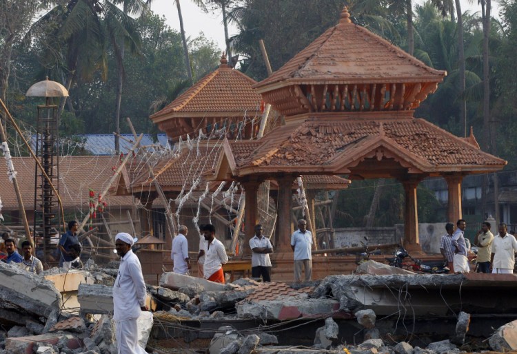 People check out the damaged structures after a massive fire broke out Sunday during a fireworks display at the Puttingal temple complex in Paravoor village, Kollam district, southern Kerala state, India, Monday.