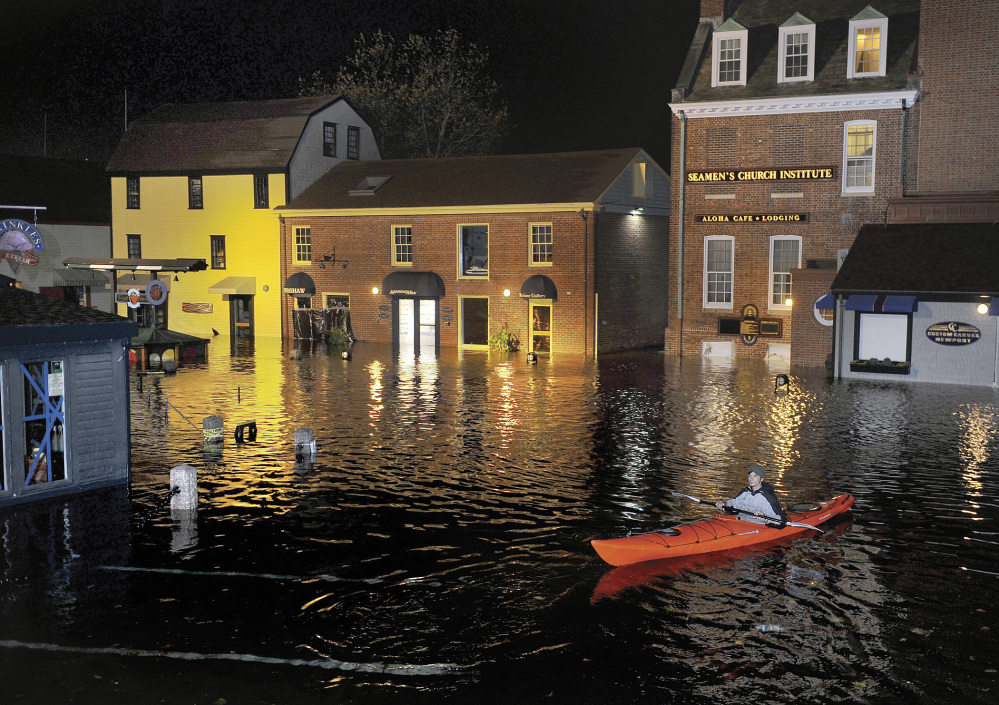 A kayaker paddles through waters flooding Bowen's Wharf after Superstorm Sandy in historic Newport, R.I.