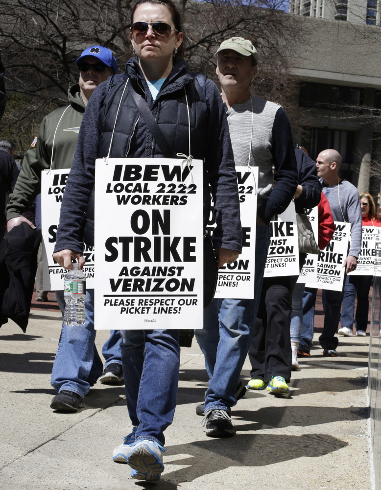 Verizon workers in Boston picket Wednesday. Tens of thousands walked off the job in several states.