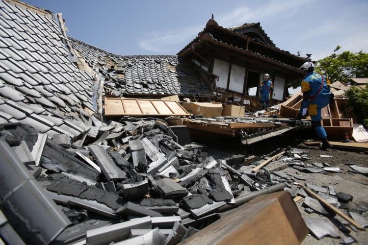 Police rescue team members search through damaged houses to check for trapped people in Mashiki, Kumamoto prefecture, southern Japan, on Friday, prior to the second earthquake striking.