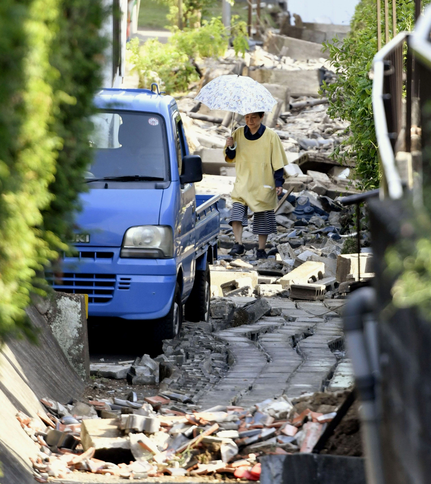 A resident walks through the debris after a magnitude-6.5 earthquake in Mashiki, Kumamoto prefecture, southern Japan, Friday.