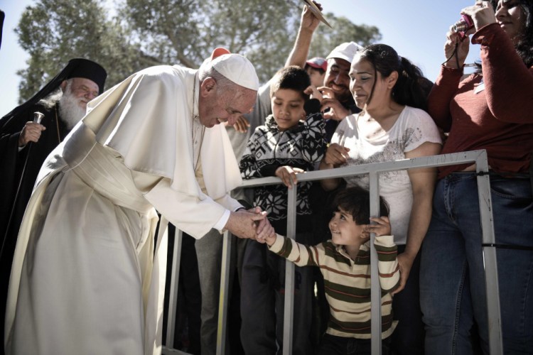 A child greets Pope Francis during a visit at the Moria refugee camp on the island of Lesbos, Greece.