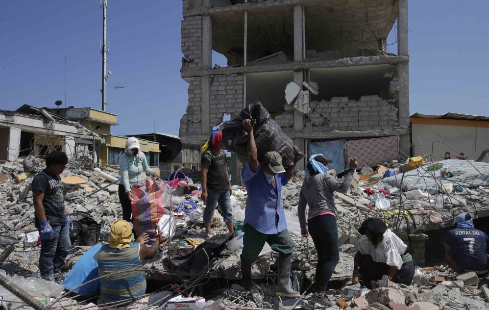 Residents recover belongings from earthquake rubble in Pedernales, Ecuador, on Tuesday. Although sniffer dogs continue to search for survivors, earth-movers began clearing areas.