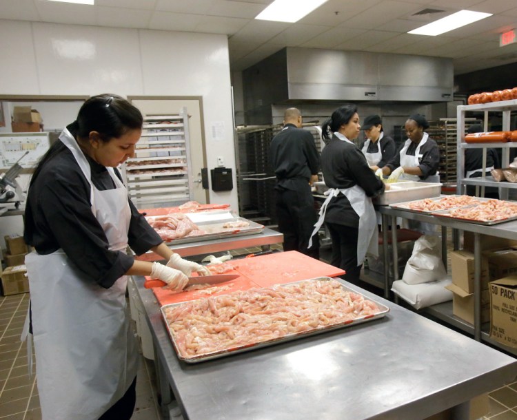 Workers prepare food in a meat-only kitchen for Passover at the Waldorf Astoria resort in Orlando, Fla., on Monday. "There is a tremendous amount of work ... goes into making a kitchen kosher," says a vacation package organizer.