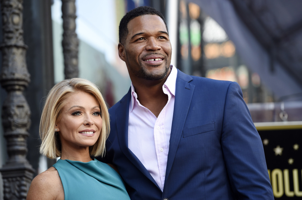 Kelly Ripa, left, poses with Michael Strahan, her co-host on the daily television talk show "LIVE! with Kelly and Michael." Ripa was absent from her daytime talk show Wednesday, the day after it was announced Strahan was leaving the show to join "Good Morning America" full time.