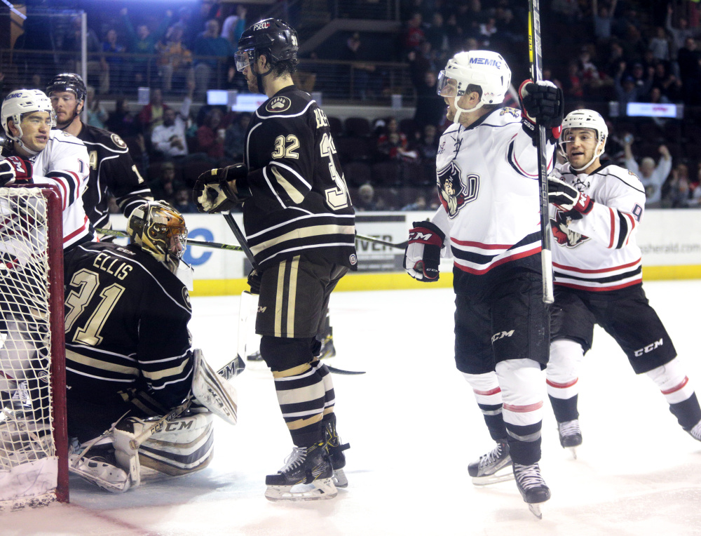 Kyle Rau, center, celebrates after giving the Portland Pirates an early lead in the first period of their 6-4 win over Hershey on Friday at Cross Insurance Arena. Portland leads the best-of-five series 1-0.