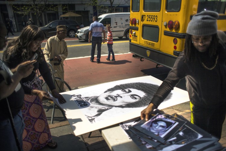 People buy posters and pictures of Prince outside of the Apollo Theater in New York on Friday.
