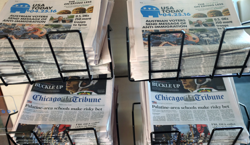 USA Today, Chicago Tribune and other newspapers are displayed at Chicago's O'Hare International Airport. Gannett is trying to buy Tribune Publishing for more than $388 million.