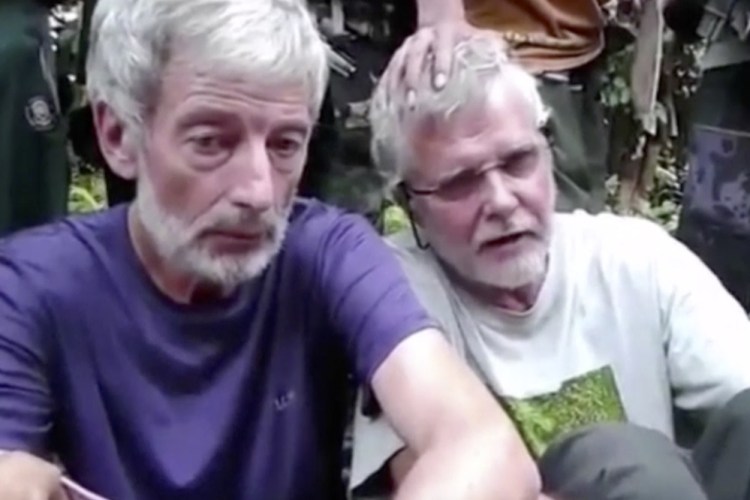 This image made from undated militant video, shows Canadians John Ridsdel, right, and Robert Hall.